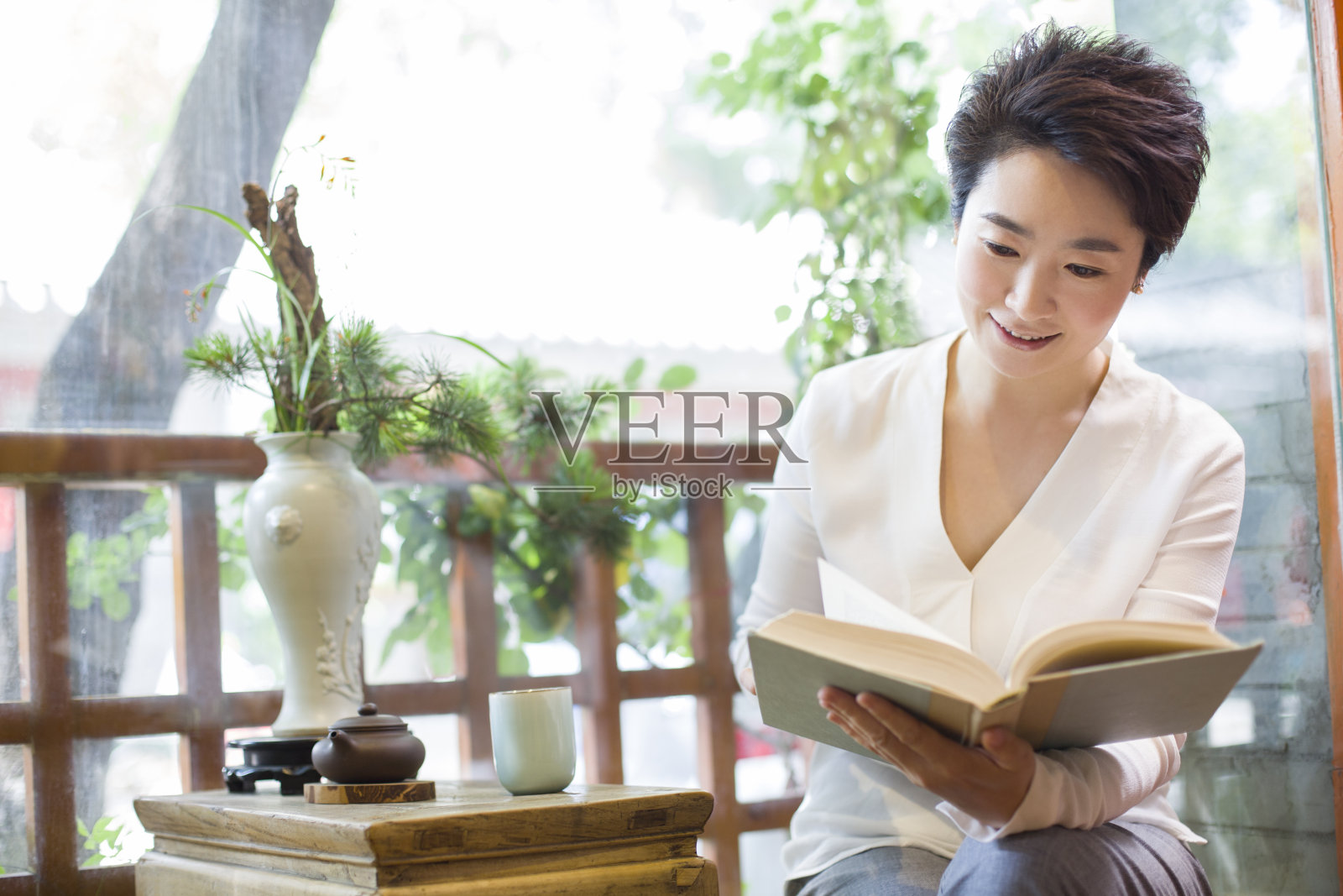 中年女子在茶馆看书照片摄影图片