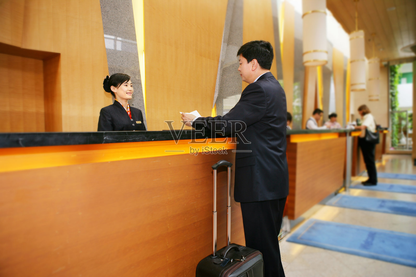 商务人士在酒店前台照片摄影图片