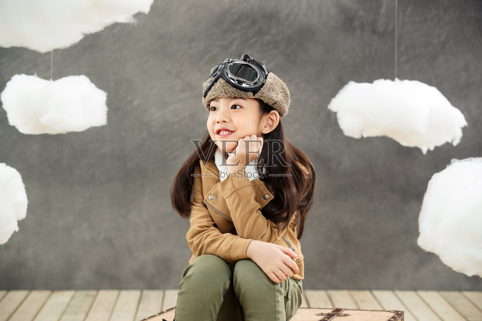 坐在行李箱上的小飞行员照片摄影图片