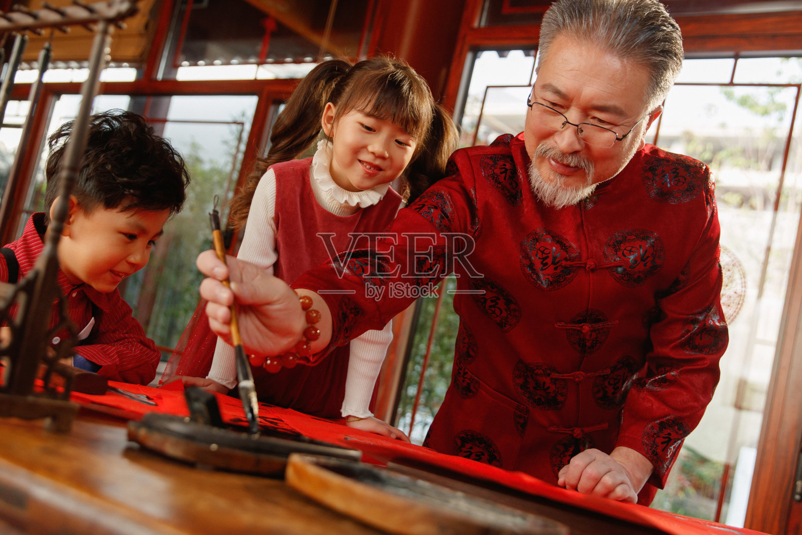 祖孙三人一起写春联照片摄影图片