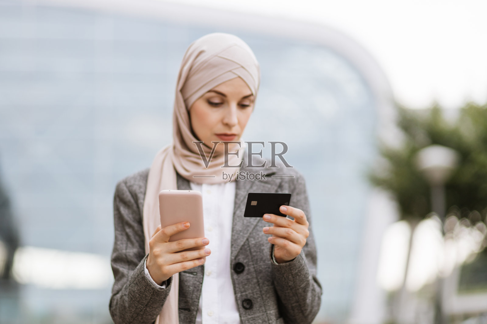 穆斯林女商人站在街上用信用卡购物照片摄影图片