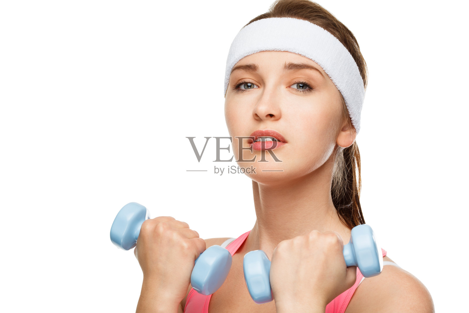 一名年轻女子在工作室背景下举重的照片照片摄影图片