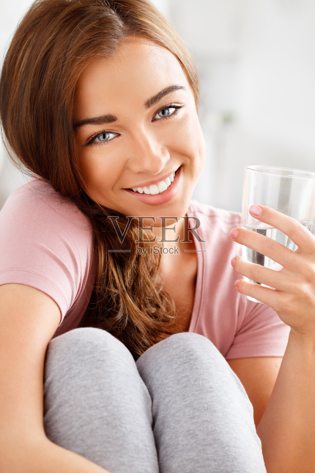 一个快乐的年轻女子正在喝一杯水照片摄影图片