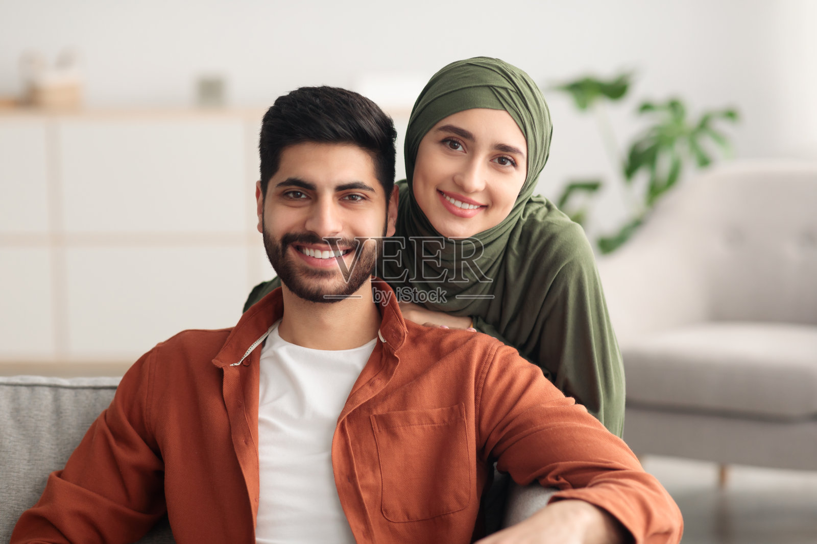 中东夫妻居家拥抱看向镜头照片摄影图片