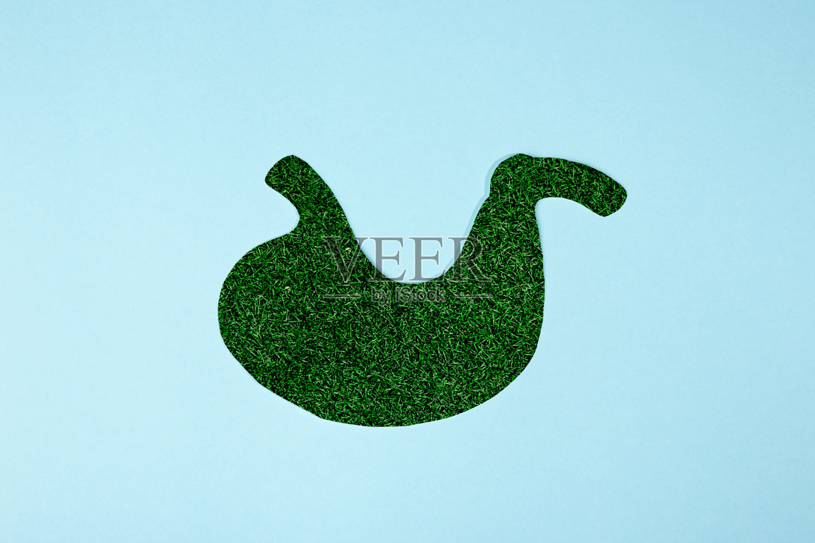 概念形象的绿草形状像人的胃。蓝色背景下的人体胃模型照片摄影图片