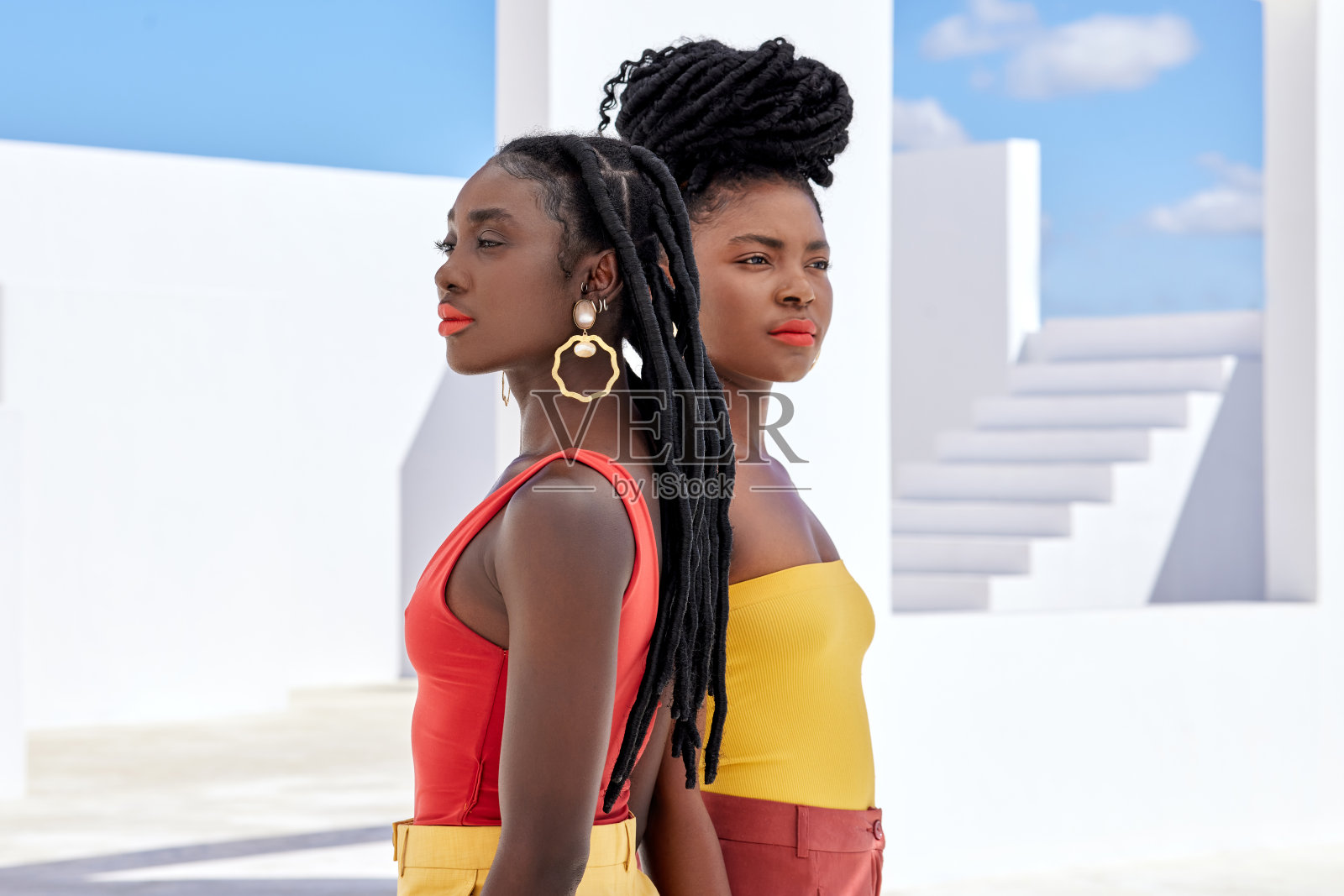 裁剪拍摄的两个有吸引力的年轻女性在户外的屋顶摆姿势照片摄影图片