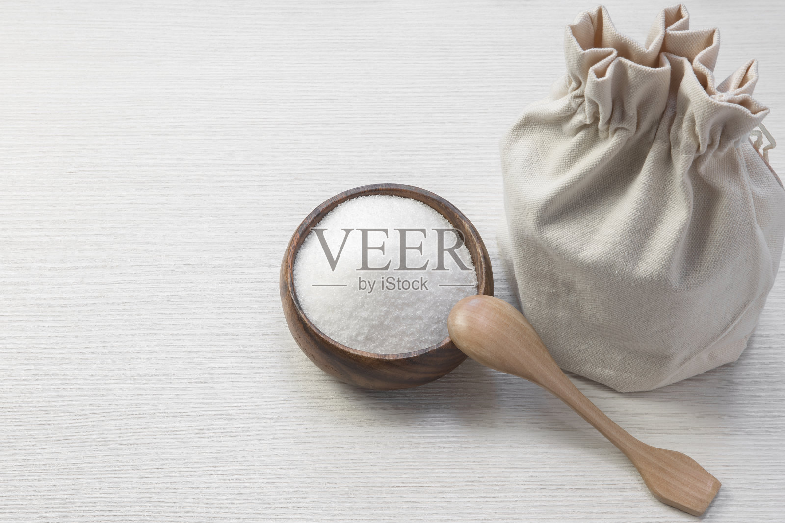 白砂糖放在碗里和木勺里。不健康垃圾食品和糖尿病的概念照片摄影图片