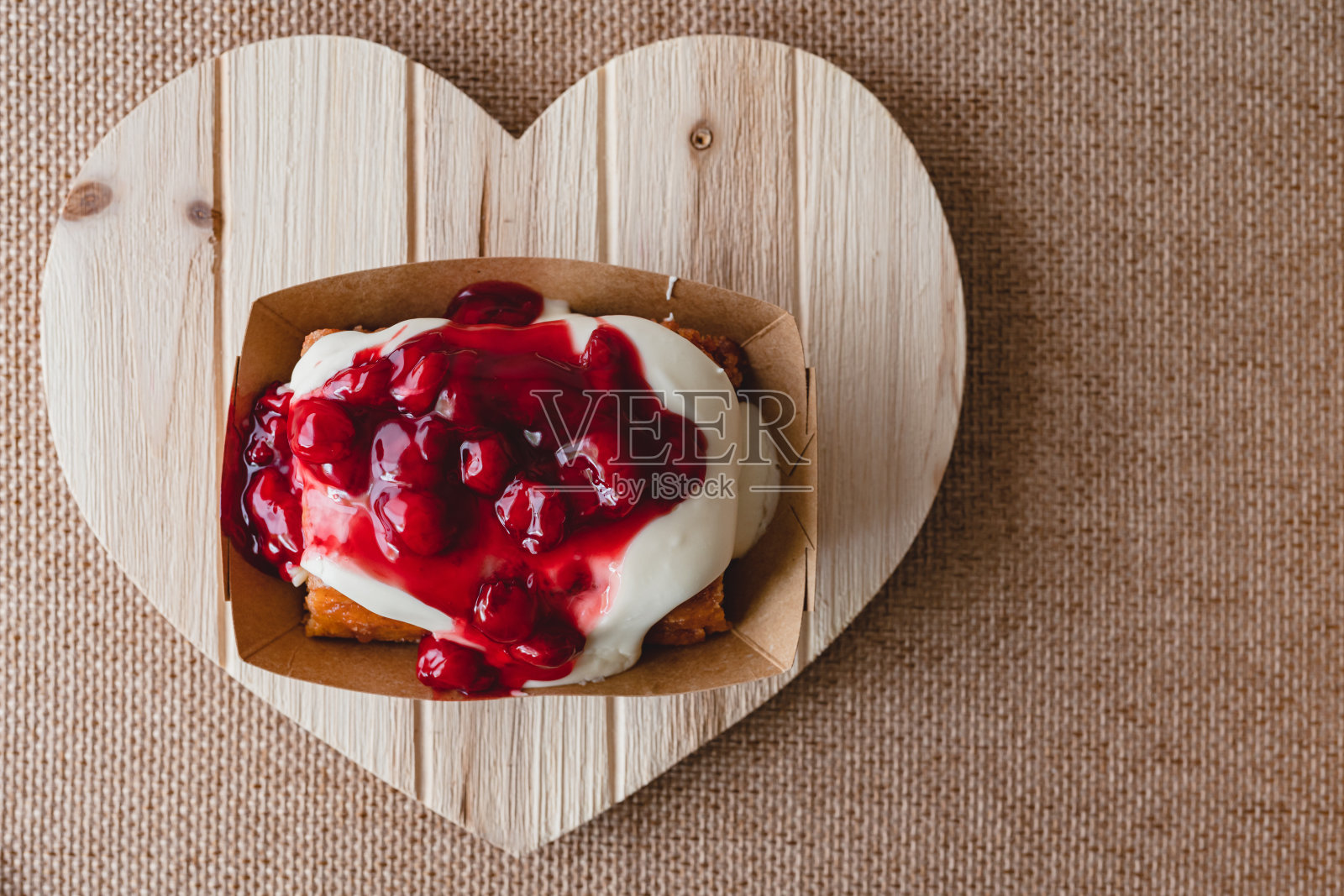 樱桃霜肉桂卷近在一个木制的心型板,平躺,复制空间照片摄影图片