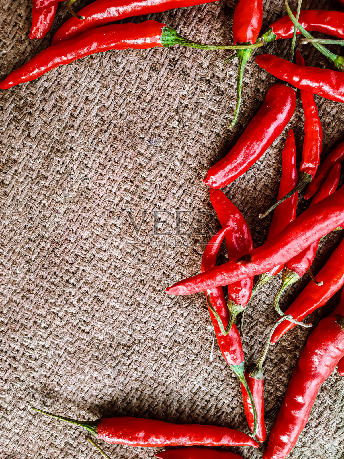 新鲜的红辣椒在旧布背景。照片摄影图片