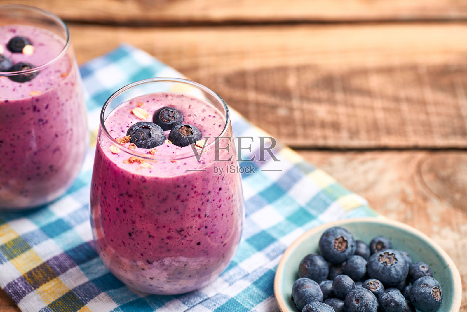 玻璃杯里的蓝莓奶昔。照片摄影图片