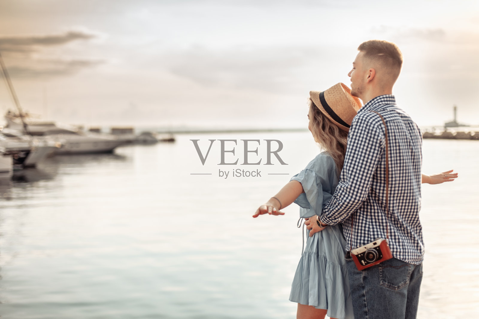 游艇俱乐部的背景是一对年轻的游客情侣。爱浪漫的概念照片摄影图片