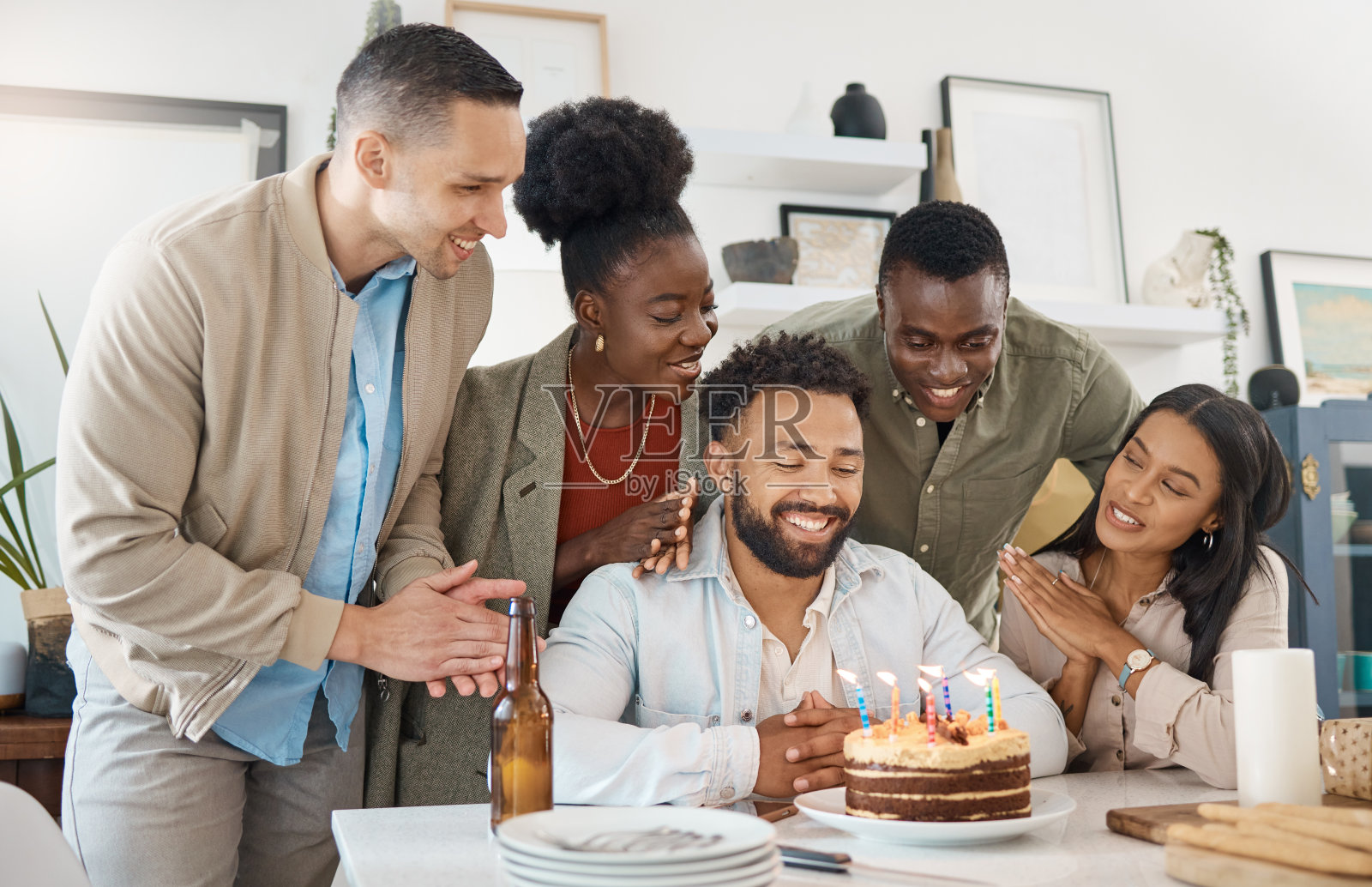 一个年轻人和朋友在家里庆祝他的生日照片摄影图片