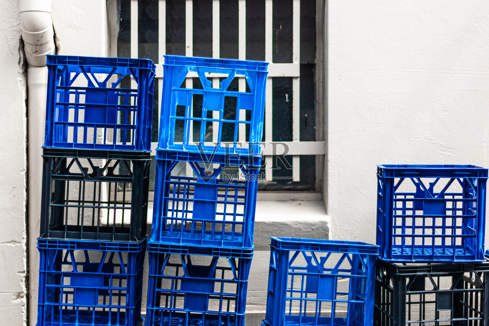 牛奶箱堆放在商店后面的墙前和窗户前照片摄影图片