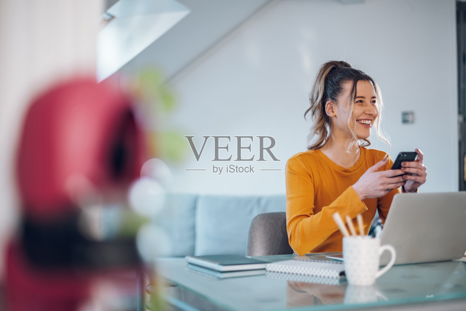 女性在家工作时使用智能手机,使用笔记本电脑照片摄影图片