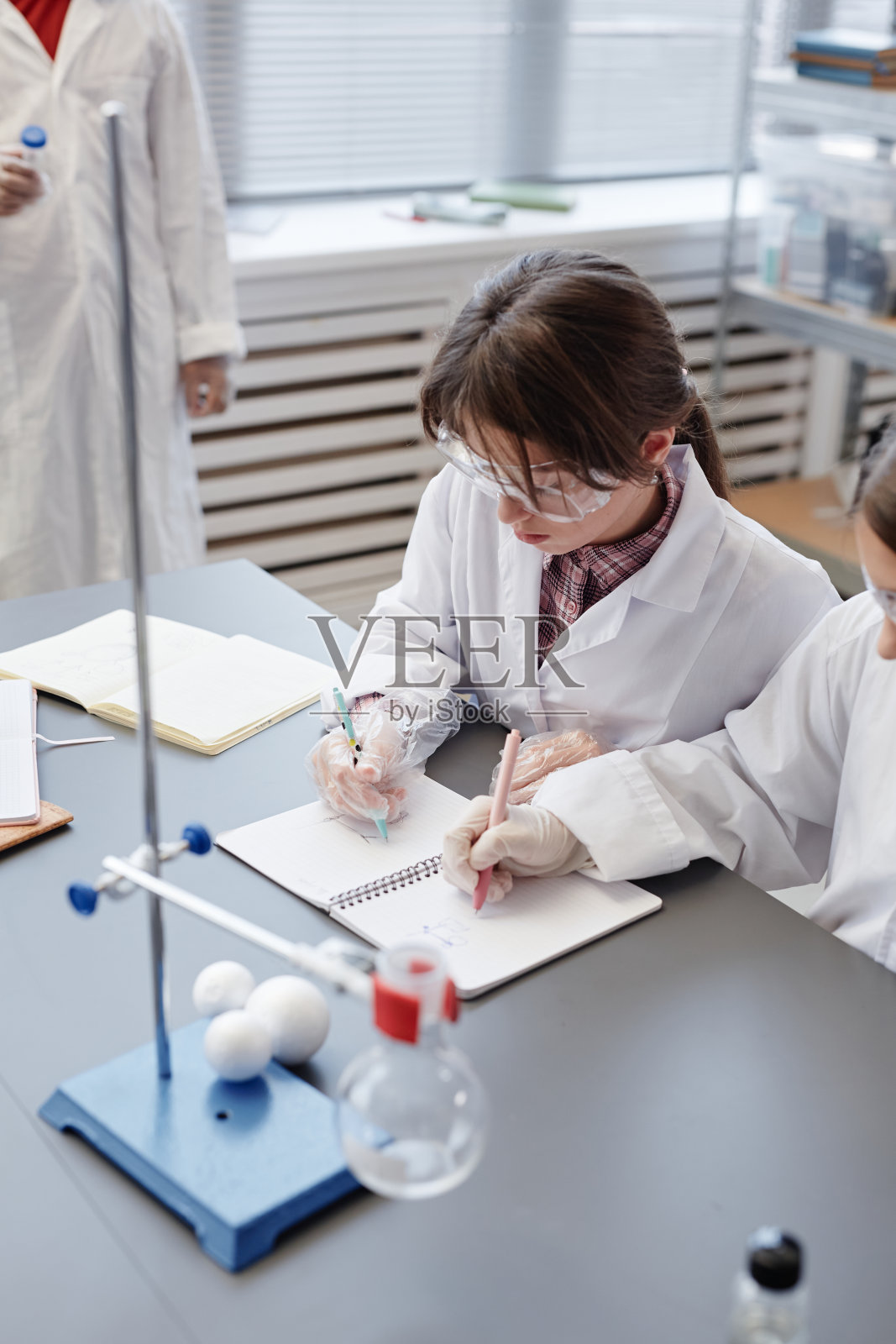 女生在学校实验室做实验笔记照片摄影图片