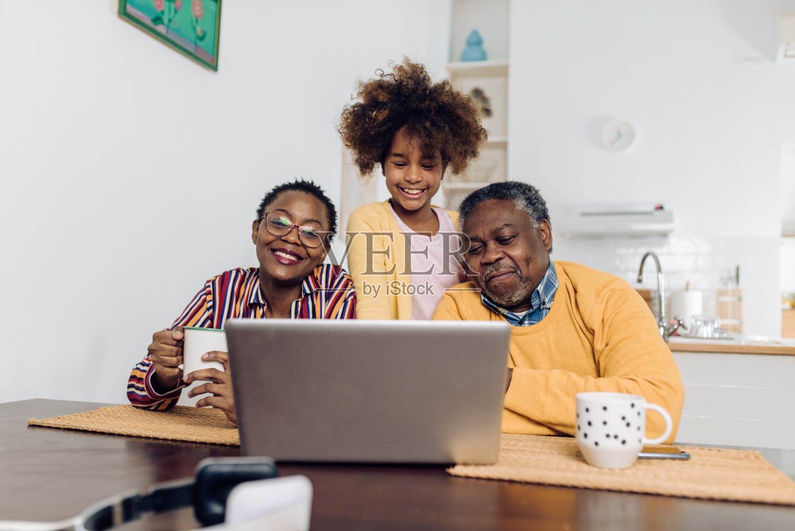 快乐的老夫妇和他们的孙女正在用笔记本电脑进行视频通话照片摄影图片