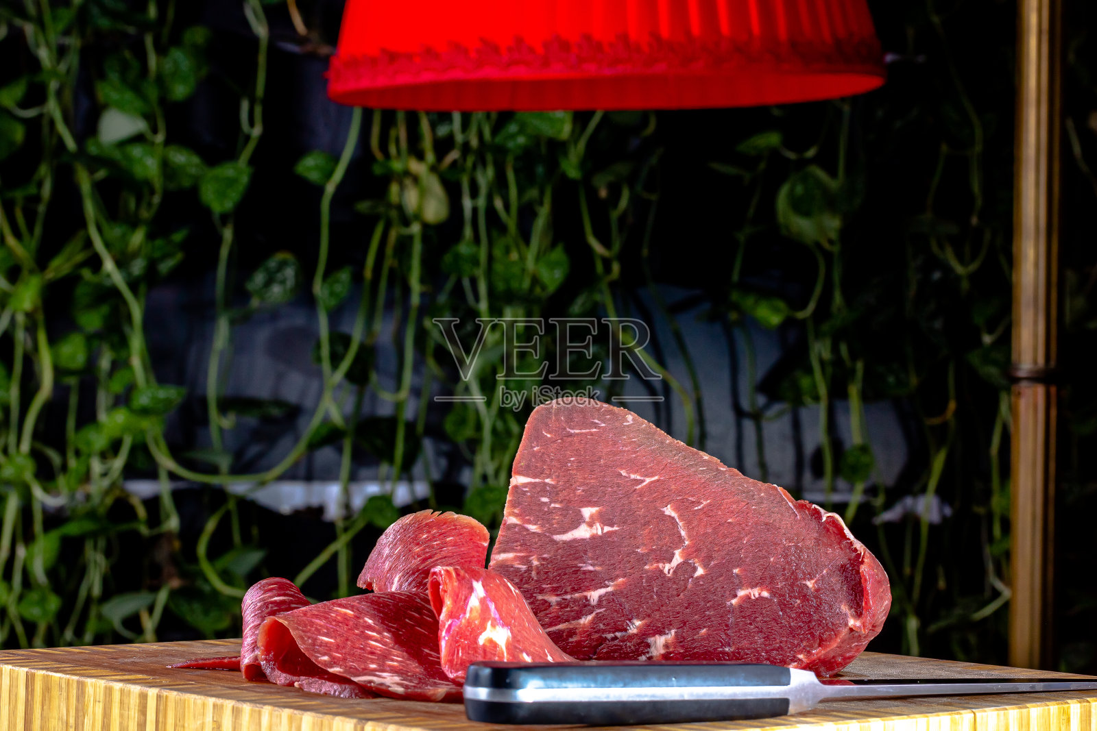 烤牛肉。切成薄片的生牛肉放在砧板上。照片摄影图片