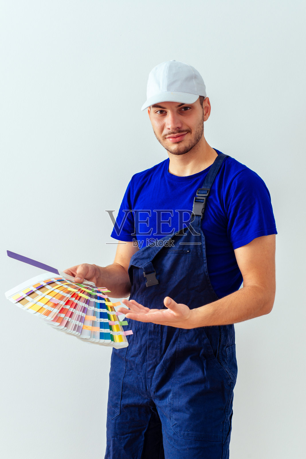 年轻的画家站在白墙前照片摄影图片