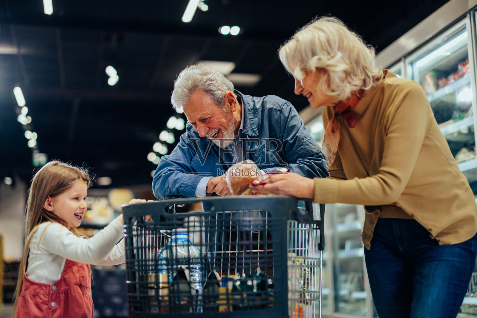快乐的祖父母和孙女在超市照片摄影图片