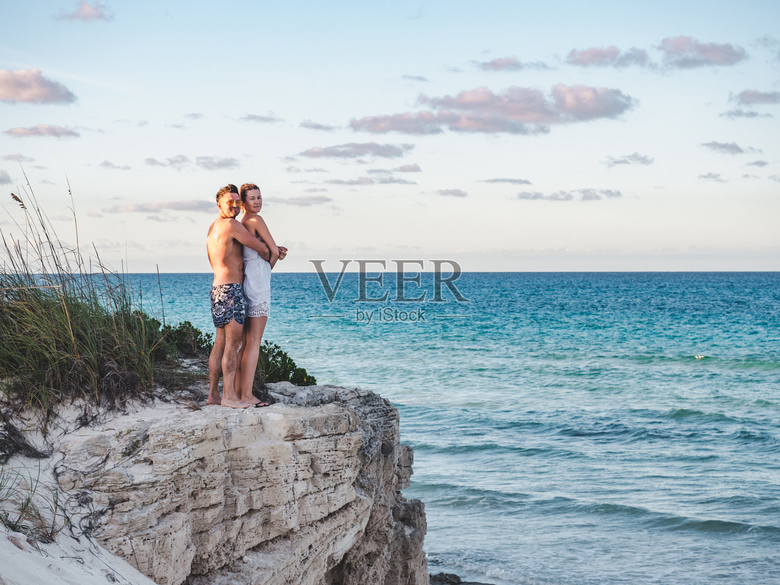 英俊的男人和漂亮的女人站在岩石的背景下照片摄影图片