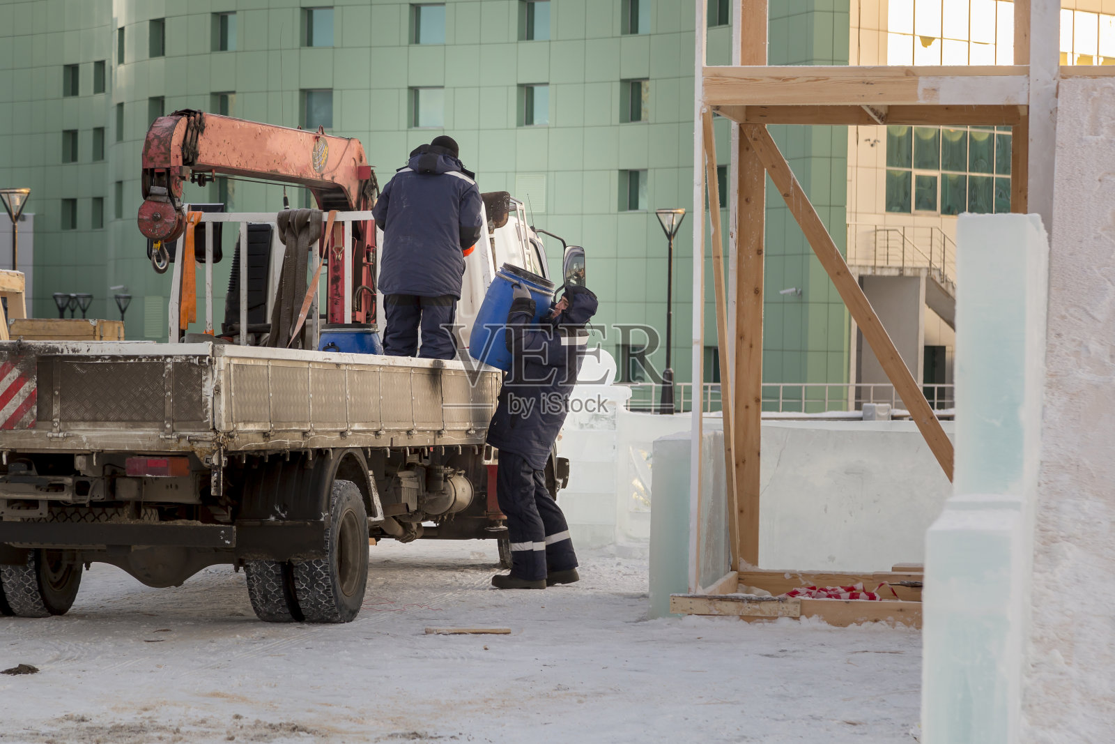 一名工人正在从车体上卸下一个桶照片摄影图片