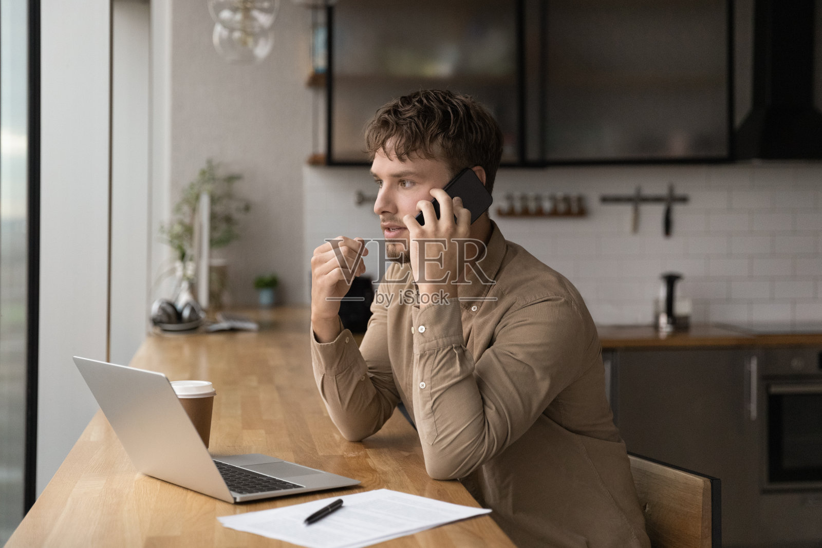 年轻男性经理在办公室里一心多用。照片摄影图片