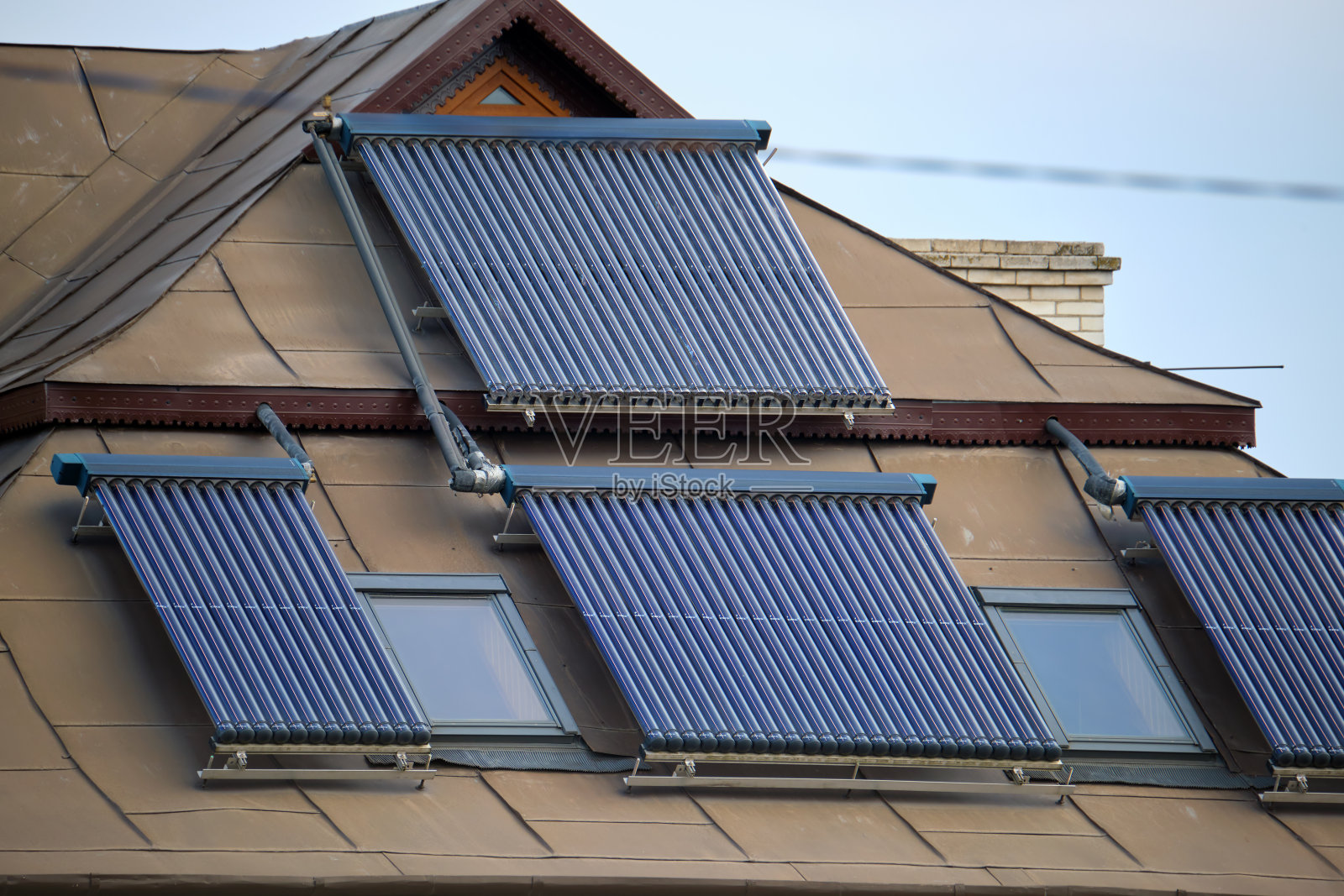 建筑屋顶装有一排排真空空气太阳能集热器,用于水加热和生产清洁生态能源。零排放的可再生热能照片摄影图片