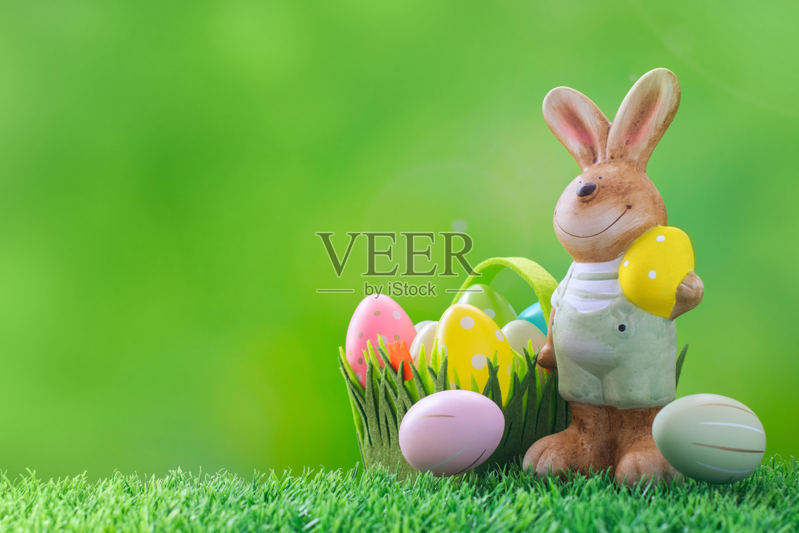 绿色草地上的复活节兔子和装饰复活节彩蛋。照片摄影图片