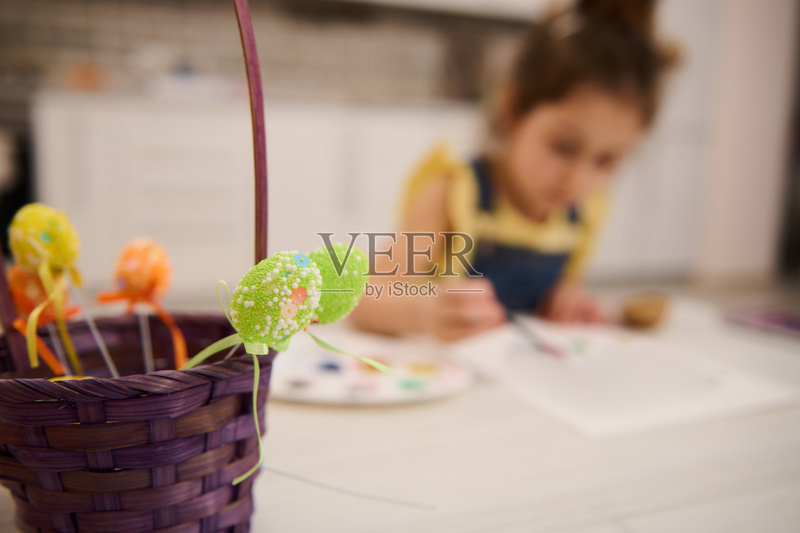 在一个可爱的女孩画和绘画背景上的复活节彩色装饰蛋软焦点在艺术创作课。复活节庆祝活动的概念照片摄影图片