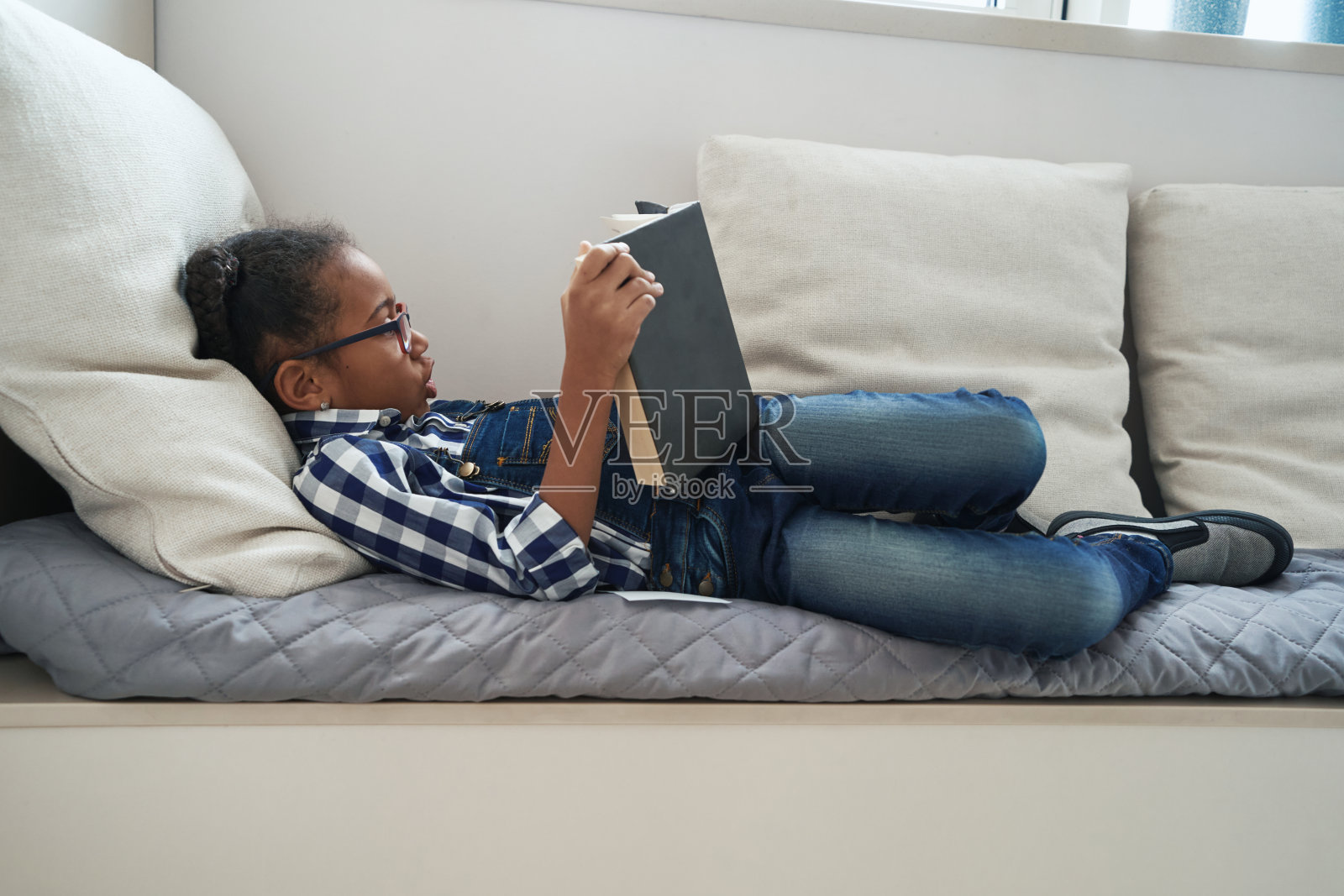 小女孩在家里津津有味地看书照片摄影图片