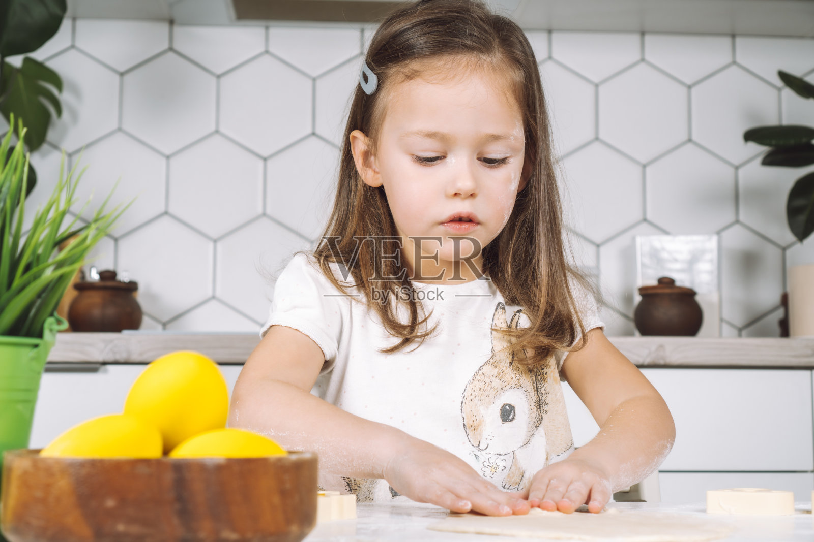 快乐专注的小女孩肖像,雕刻面团形状的饼干,烘焙杯。复活节活动准备照片摄影图片