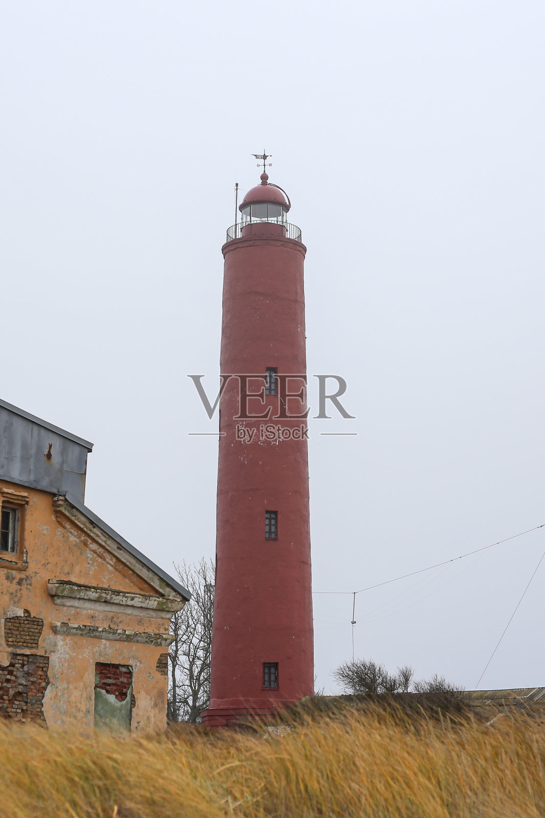 拉脱维亚波罗的海附近古老的红色灯塔,称为Akmensraga灯塔。照片摄影图片
