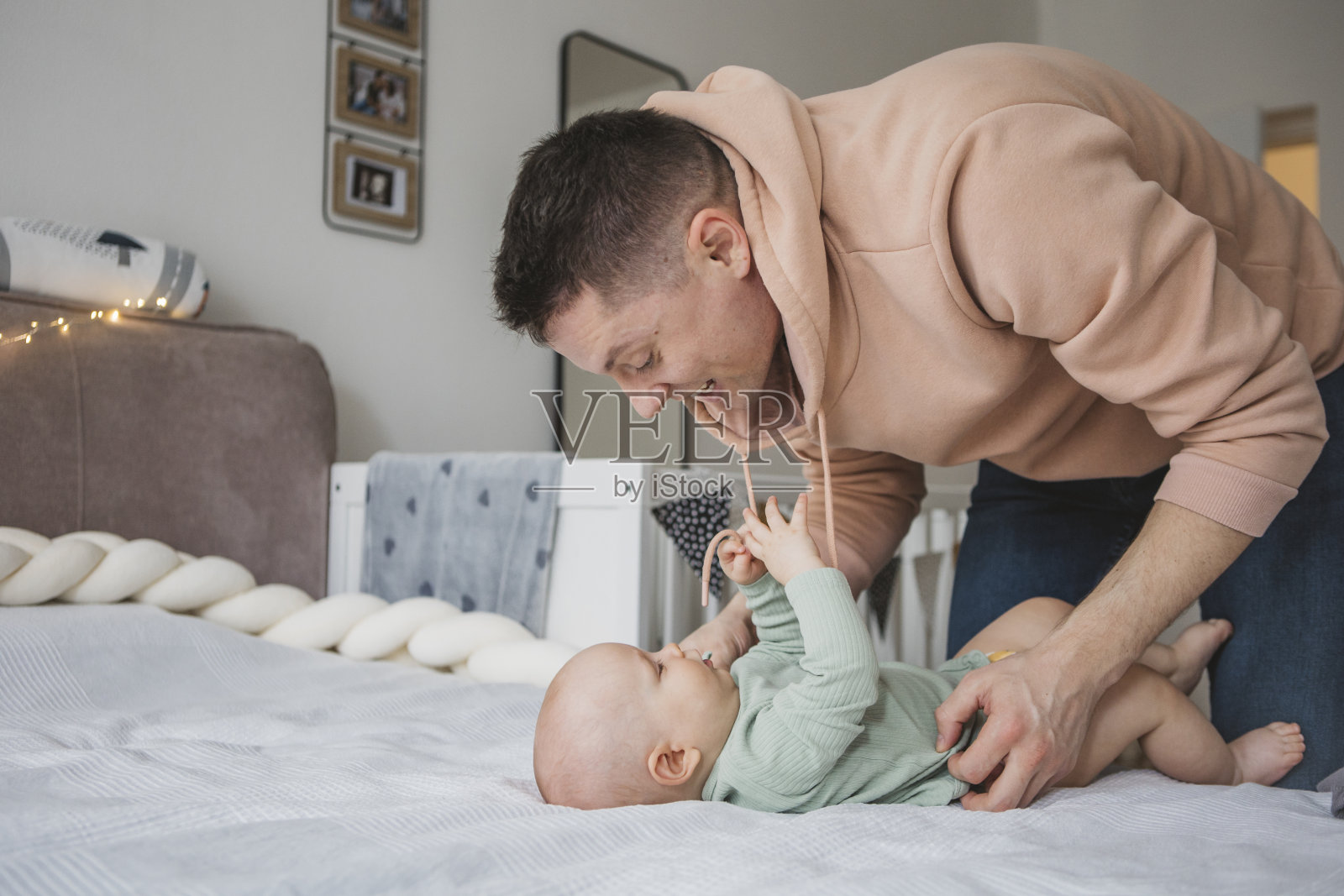 爸爸和宝宝在床上玩耍照片摄影图片