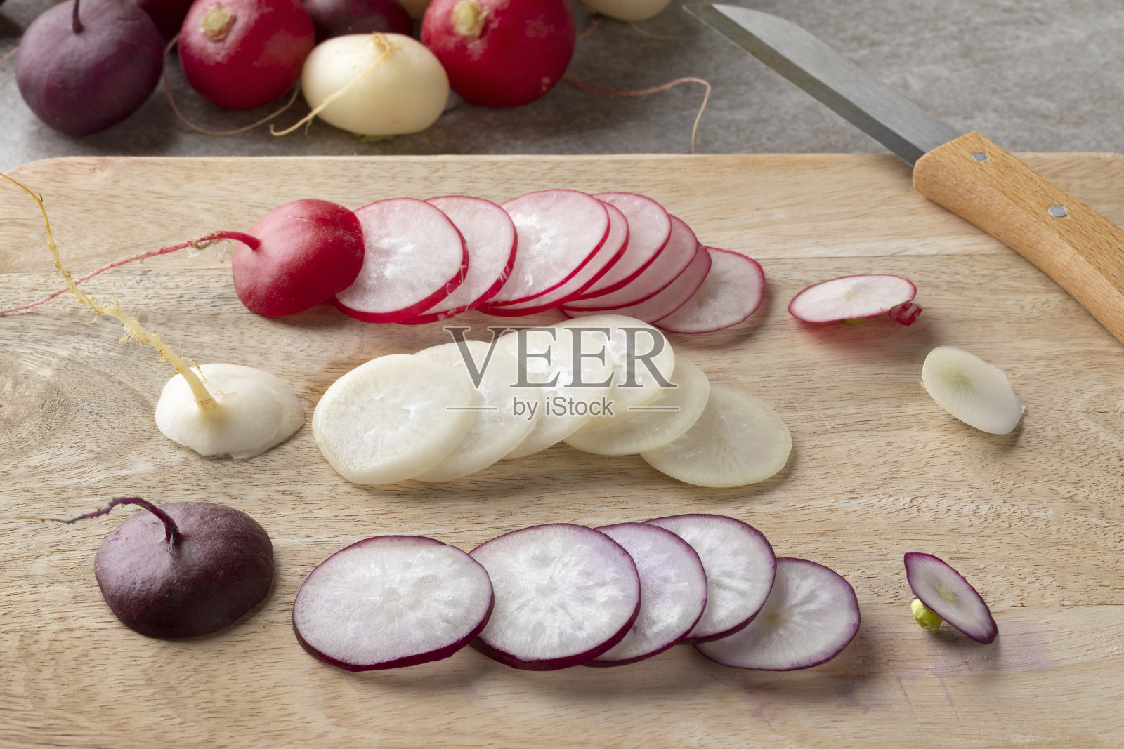 新鲜的彩色萝卜片靠近砧板照片摄影图片