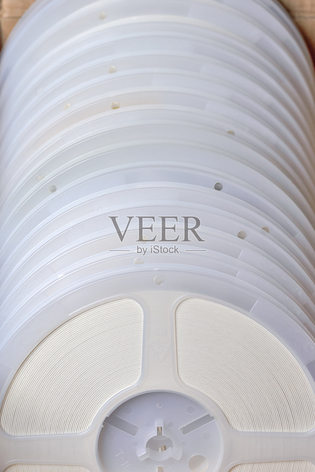 电子工业的概念。批量的贴片或表面贴装组件在磁带和卷筒架上一起堆叠。照片摄影图片