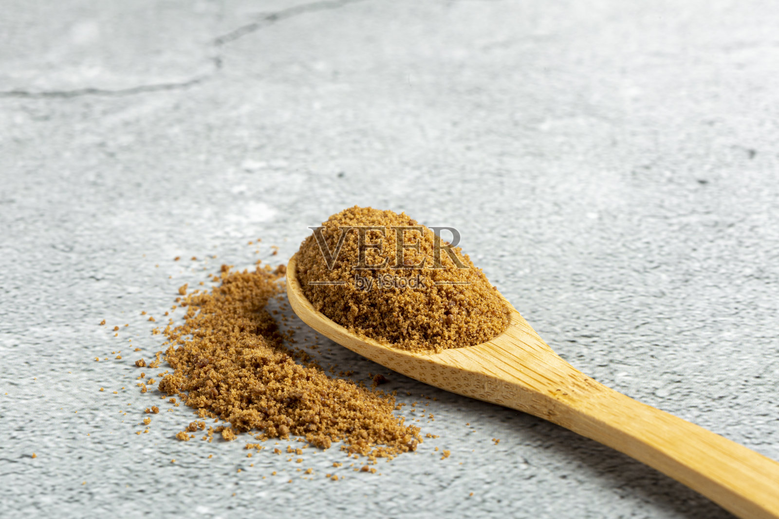 桌上的木勺里放着红糖。照片摄影图片