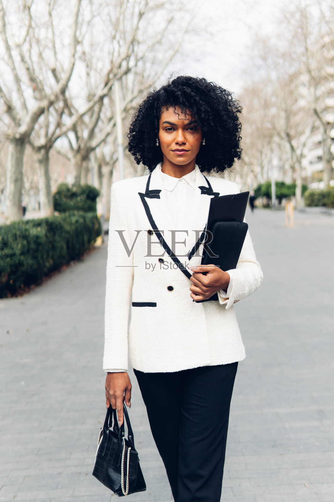 女商人拿着文件夹和钱包正往前走照片摄影图片