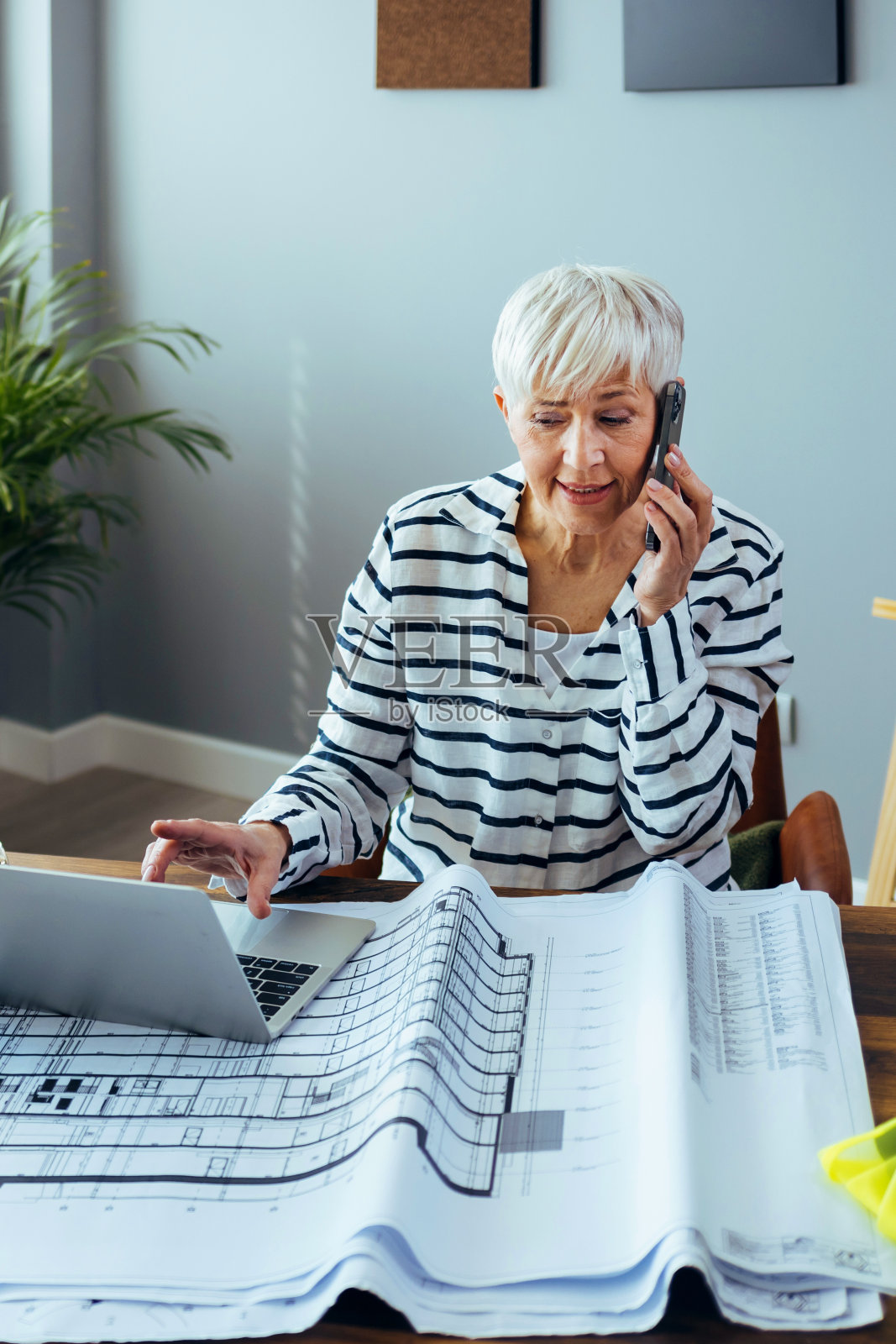 建筑师的女性在她的办公室工作时使用手机照片摄影图片