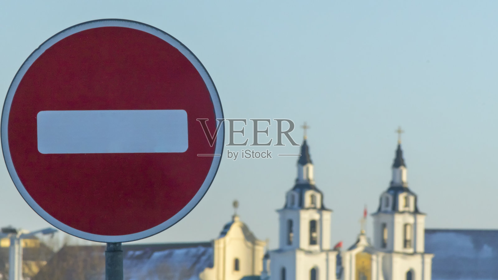 禁止进入道路标志在旧东正教教堂的背景上。冬天。这条路是封闭的,红色的圆形标志。照片摄影图片