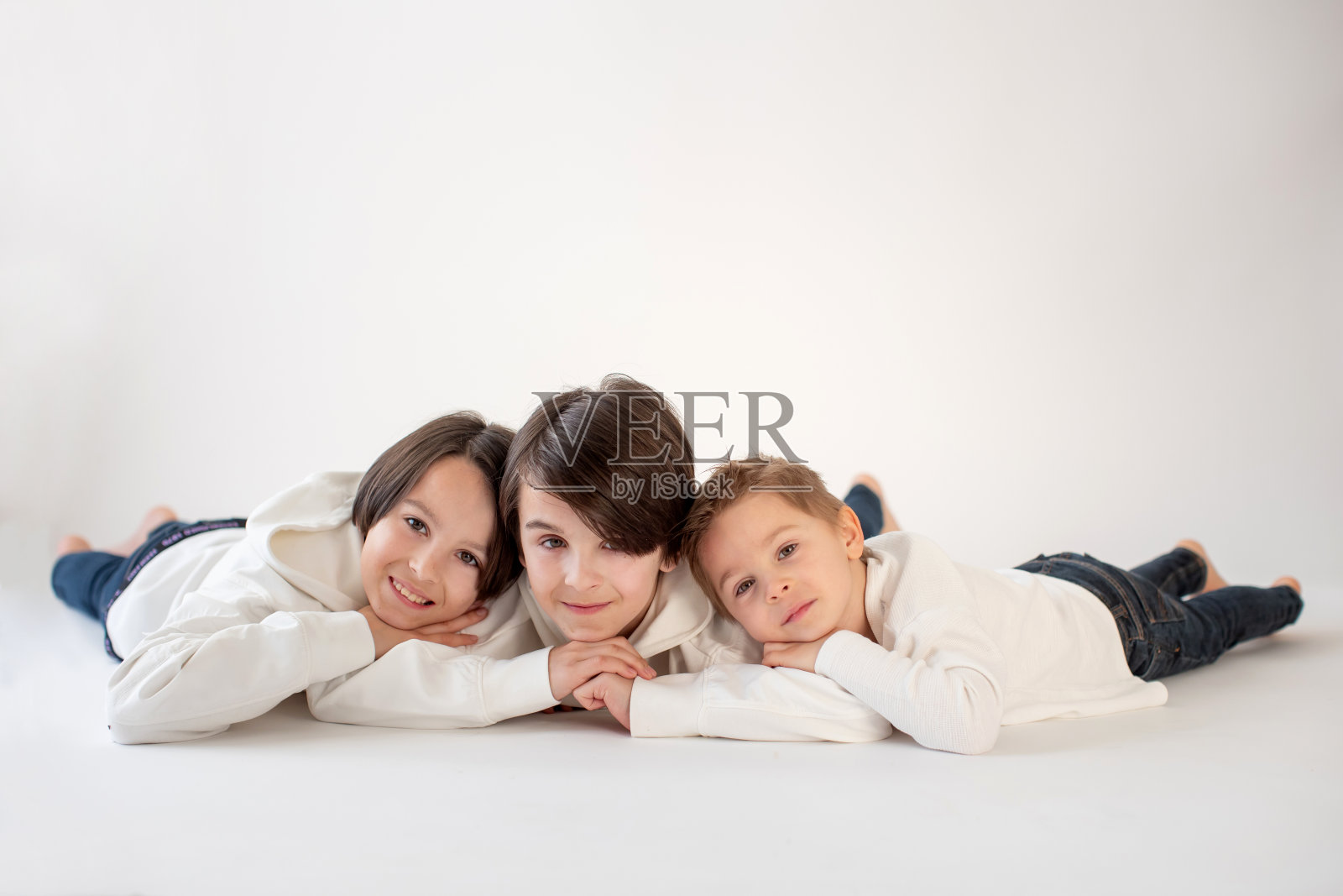 可爱时尚的蹒跚学步的孩子和哥哥,白色背景的白衬衫的男孩,家庭孩子的肖像照片摄影图片