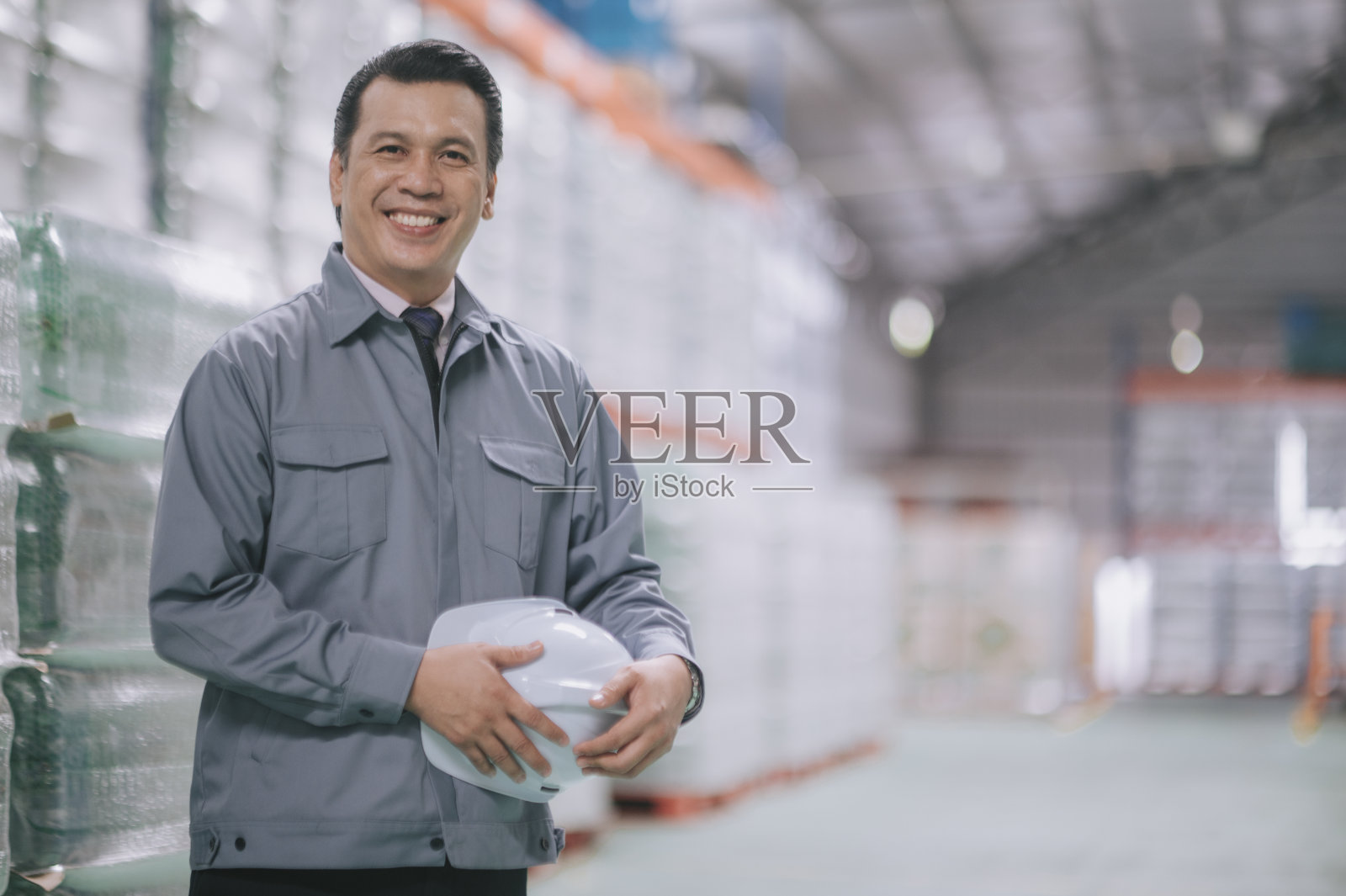 亚洲马来人成熟男子仓库经理看着镜头微笑在卡车前的仓库照片摄影图片