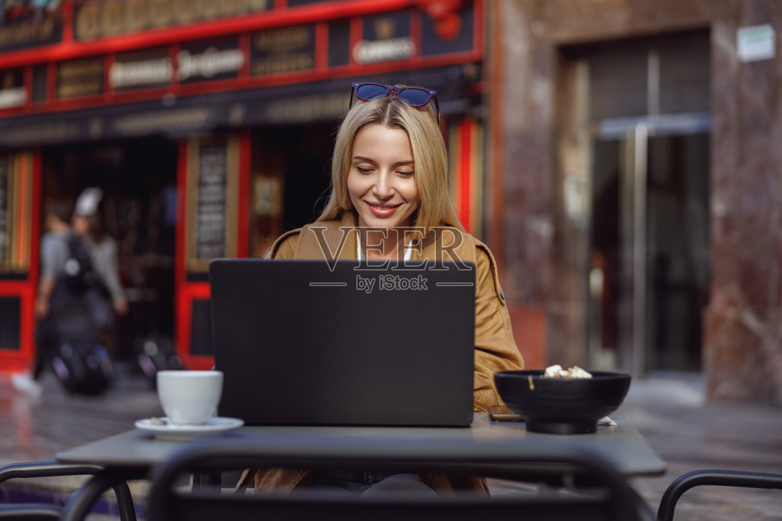 女人一边看着笔记本电脑屏幕一边学习照片摄影图片