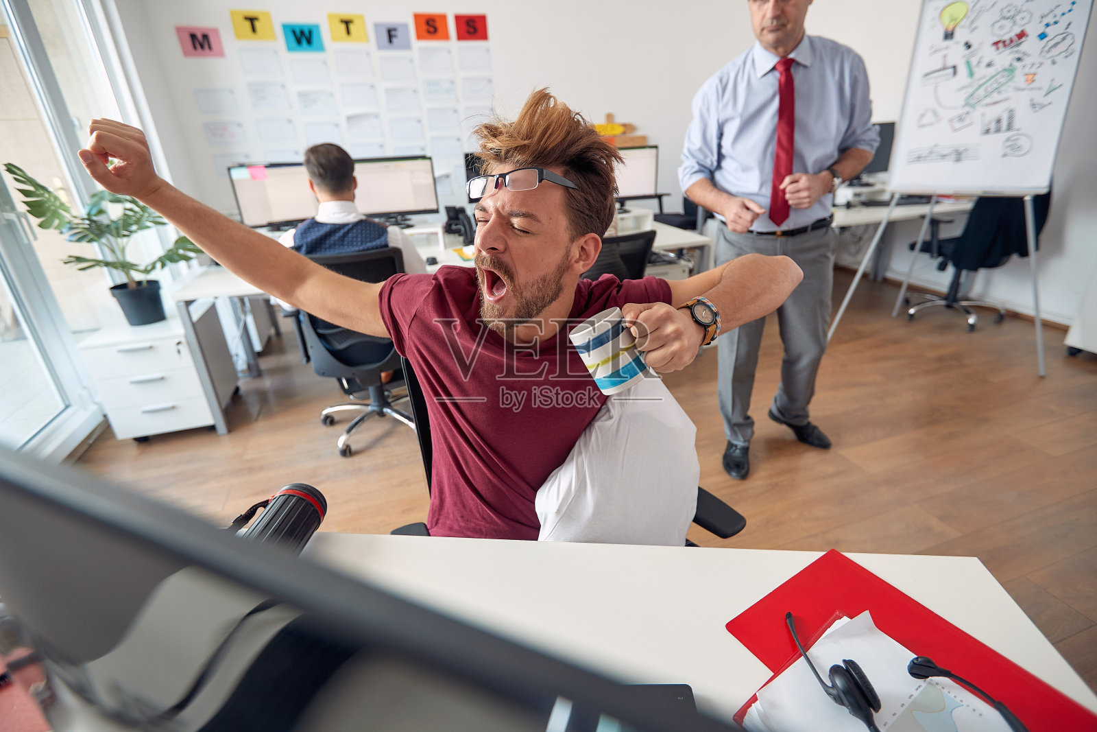 一名疲惫的男性员工在办公室工作时趴在桌子上睡着了。员工的工作,办公室照片摄影图片