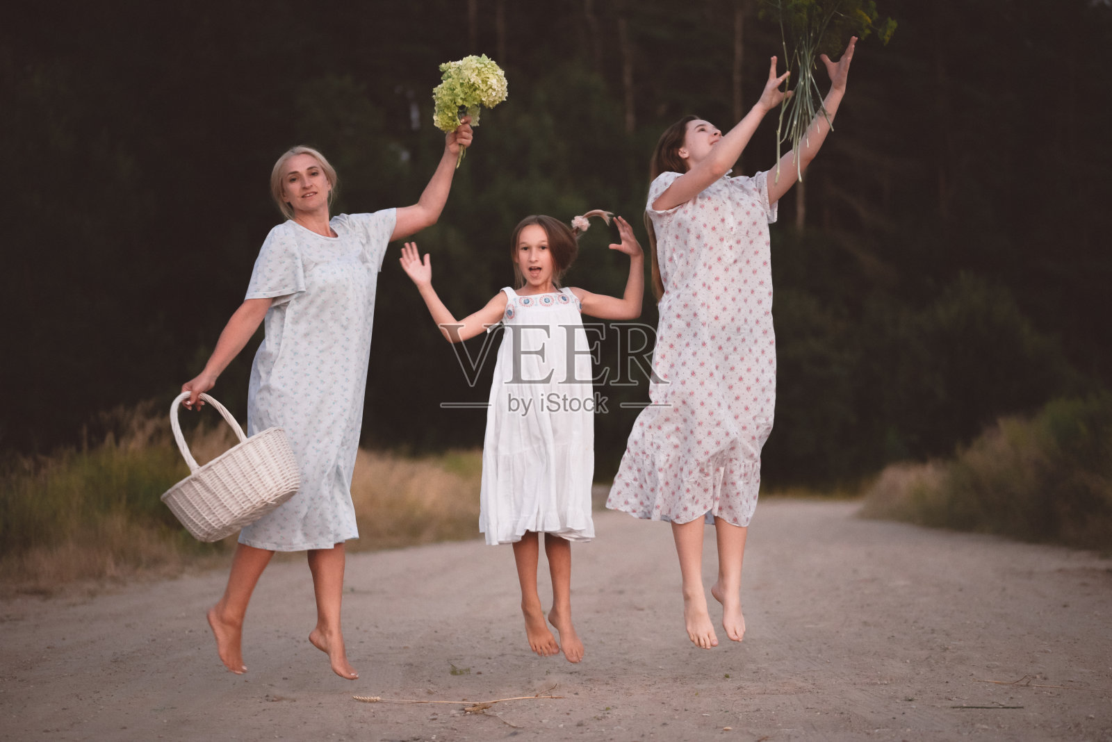妈妈和女儿们在森林附近赤脚呼吸新鲜空气,享受欢乐的家庭出游照片摄影图片