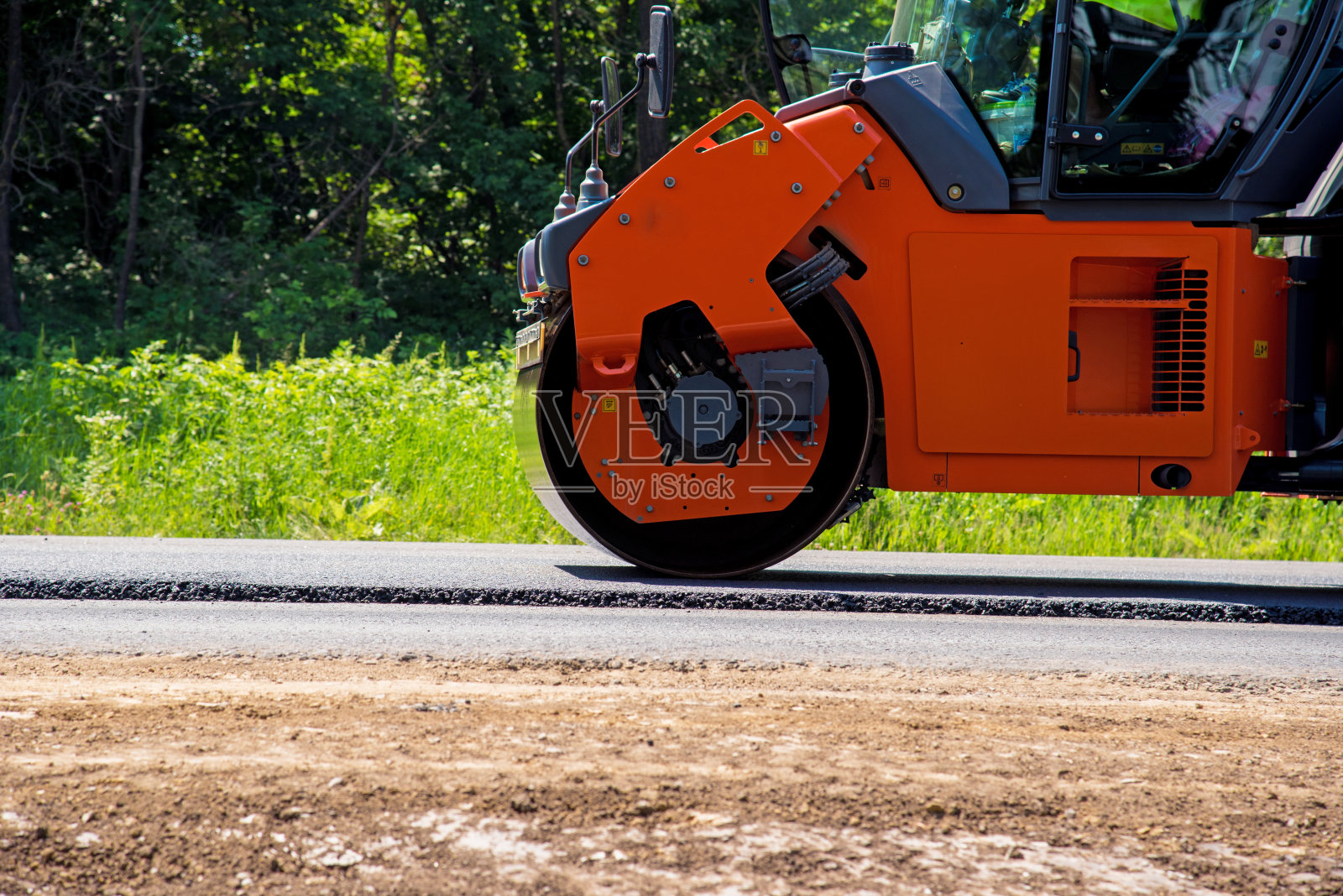工业景观用压路机在路面上滚动新的沥青。维修,运输运动复杂。照片摄影图片