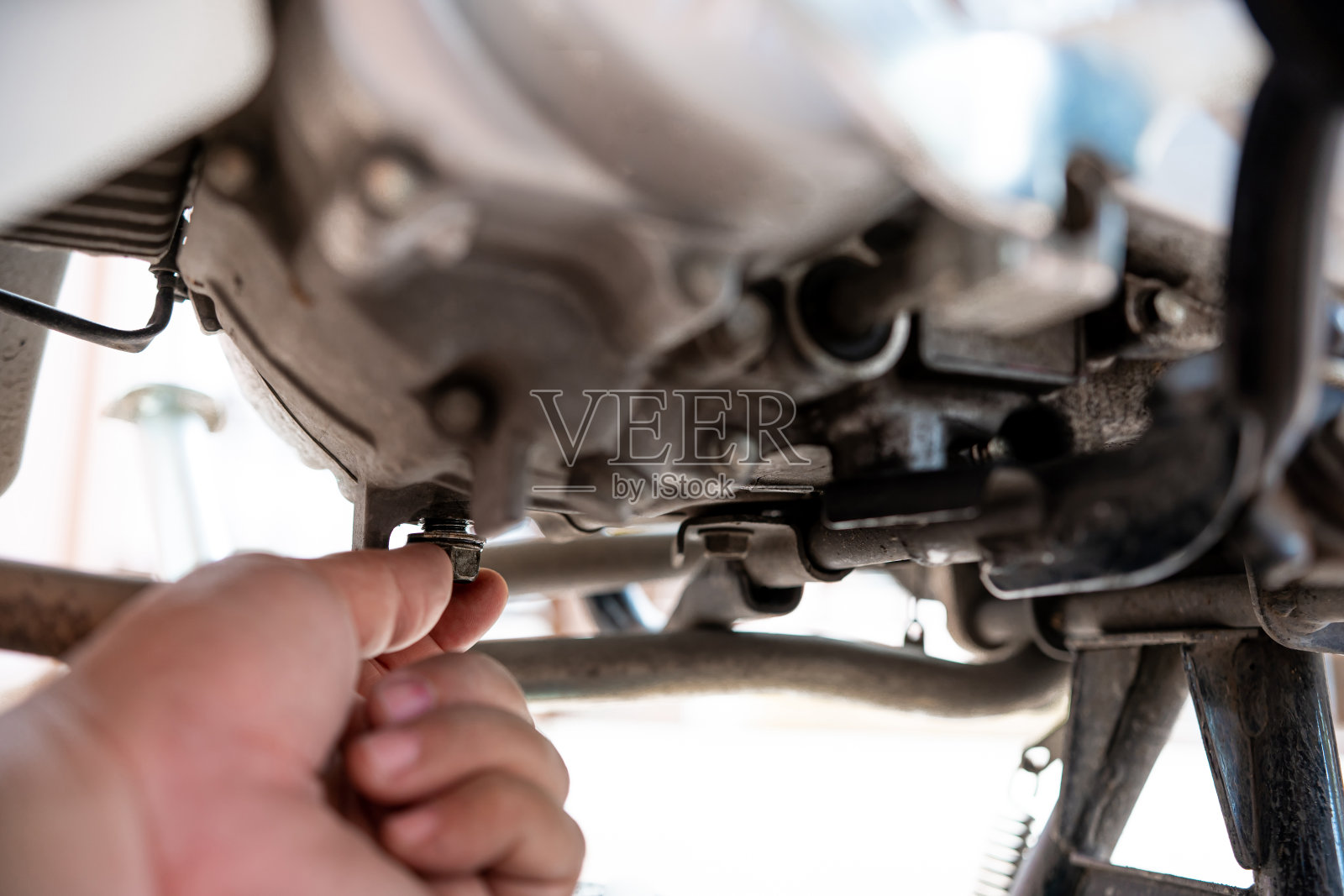 合上发动机摩托车的螺母油盘,手动拆卸,方便更换发动机机油维修保养回路照片摄影图片