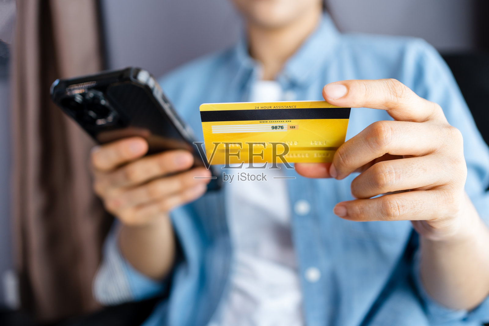 女性在家里持有信用卡和使用智能手机,女商人在线购物,电子商务,网上银行,消费,在家工作的概念照片摄影图片