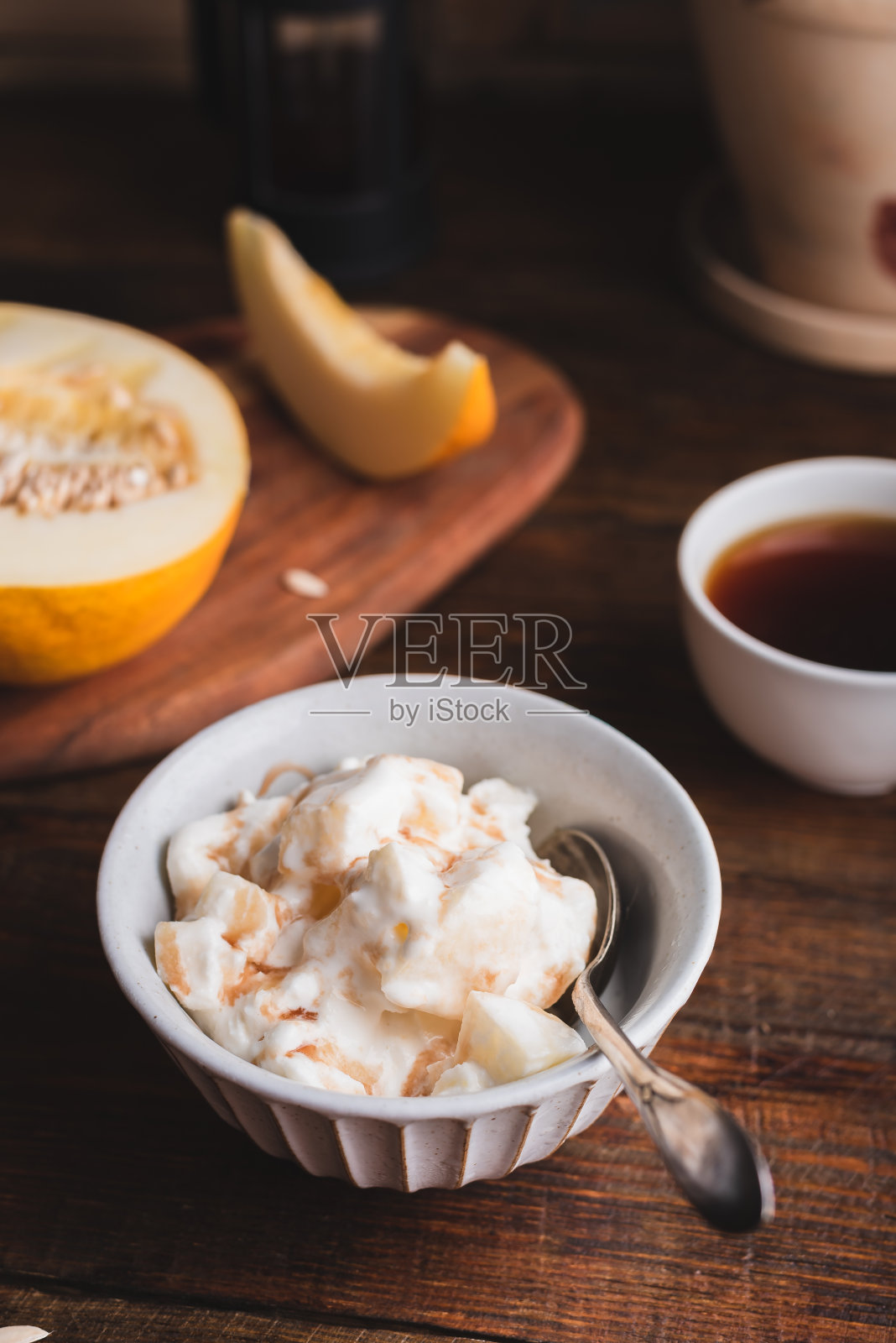 用勺子舀甜瓜冰淇淋和甜糖浆照片摄影图片