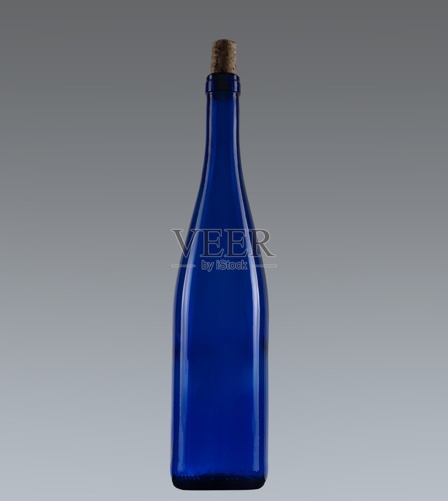 蓝色葡萄酒类型酒瓶与软木塞,在灰色梯度背景。照片摄影图片