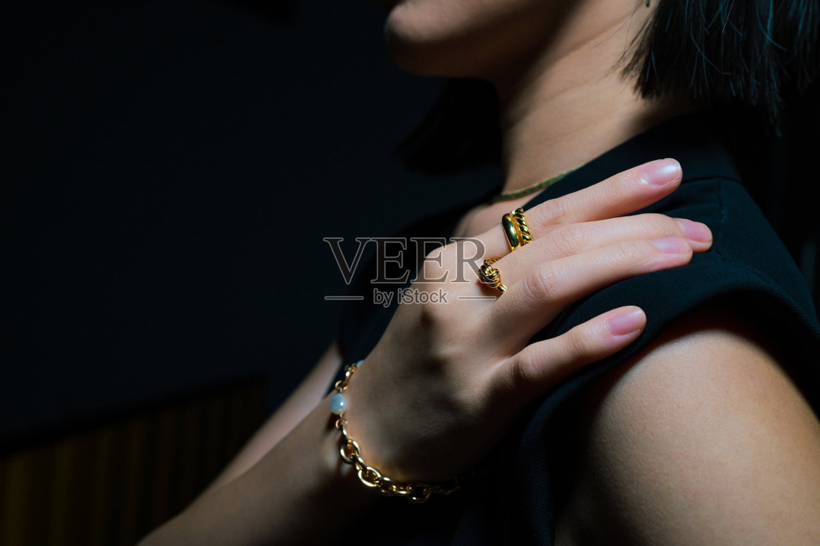 闭合的金戒指和手镯上的妇女的手照片摄影图片